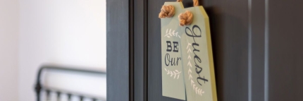 Schild mit Aufschrift be my Guest an Hoteltüre